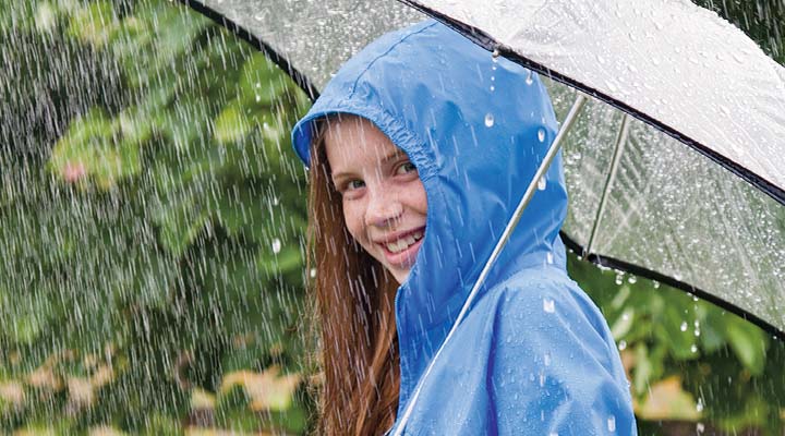 Teenager under an umbrella while it&apos;s raining